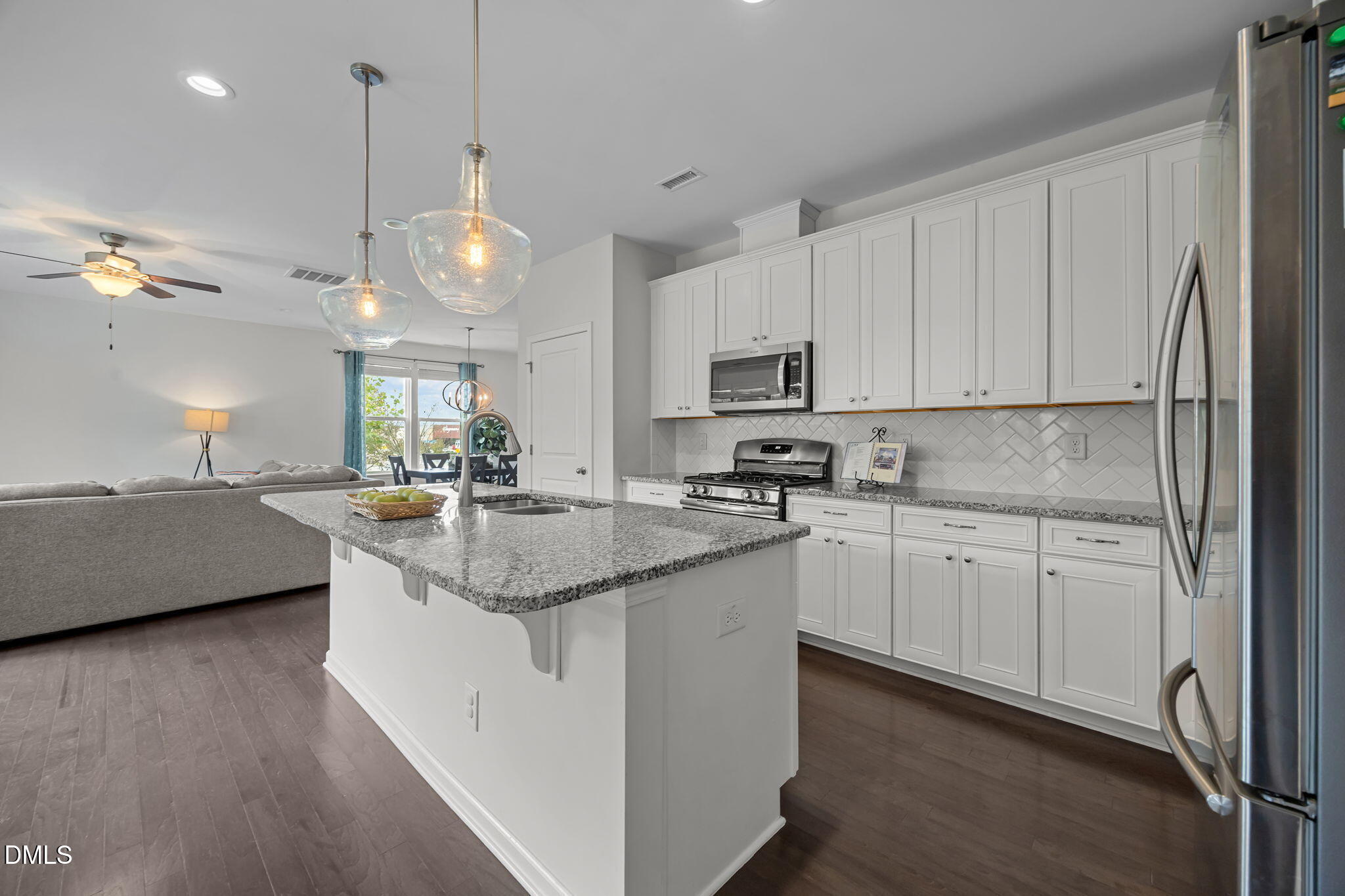 1525 Reynolds Mill Road Wake Forest, NC 27587 - Photo 16 of 40 a kitchen with kitchen island granite countertop a sink cabinets and stainless steel appliances