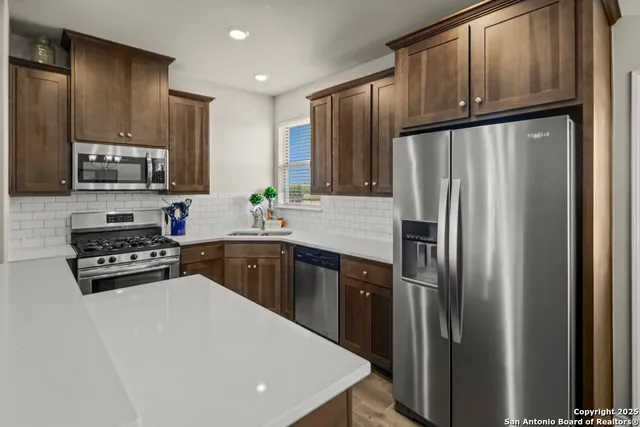 a kitchen with stainless steel appliances granite countertop a stove refrigerator sink and cabinets