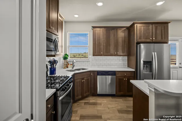 a kitchen with stainless steel appliances granite countertop a sink stove and refrigerator