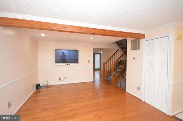 a view of a hallway with wooden floor and staircase