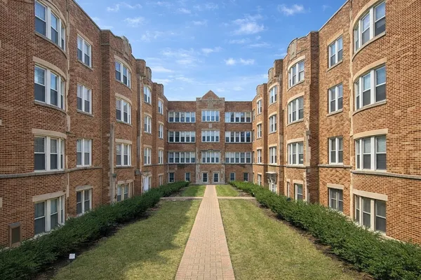 a view of a brick building next to a big yard