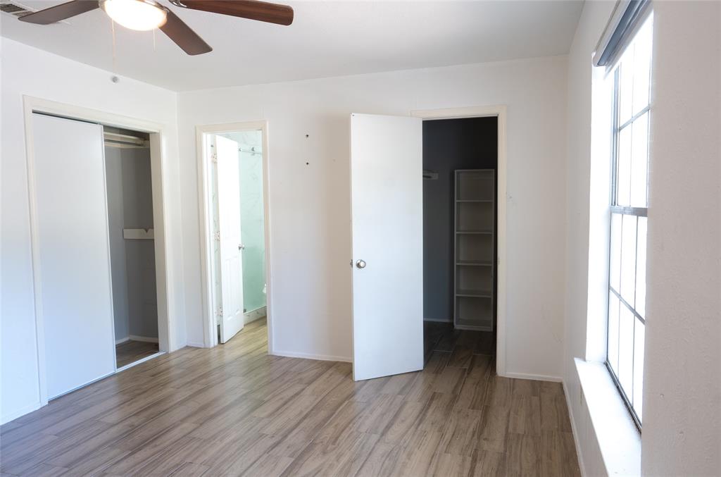 2904 South Fielder Road Arlington, TX 76015 - Photo 11 of 21 Wood-finish flooring, ceiling fan, white paneled doors, sliding closet doors, and a window with grid detailing