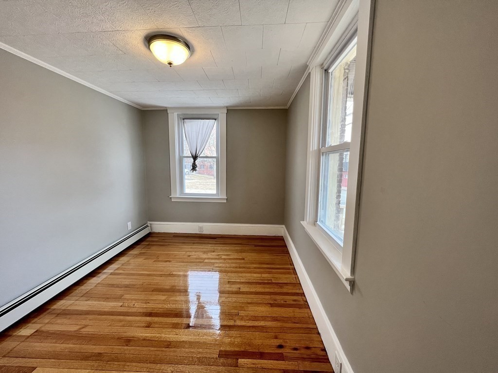 68 Bemis Road, Unit 1 Fitchburg, MA 01420 - Photo 8 of 10 a view of an empty room with wooden floor and a window