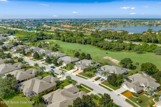 a kitchen with a refrigerator a sink dishwasher a dining table and chairs with wooden floor