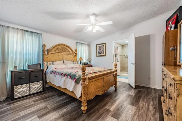 a bedroom with a bed wooden floor and window