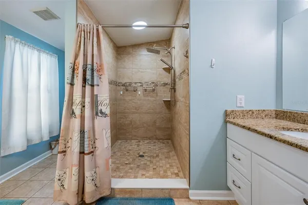 a bathroom with a granite countertop shower mirror and a sink