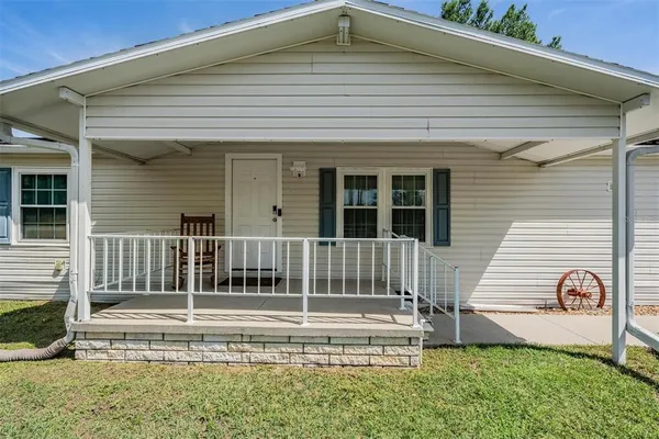 a view of a house with a small yard and wooden floor and fence
