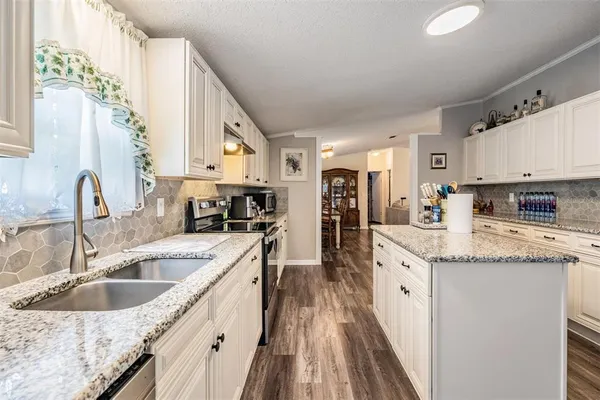 a kitchen with a sink stove top oven and refrigerator