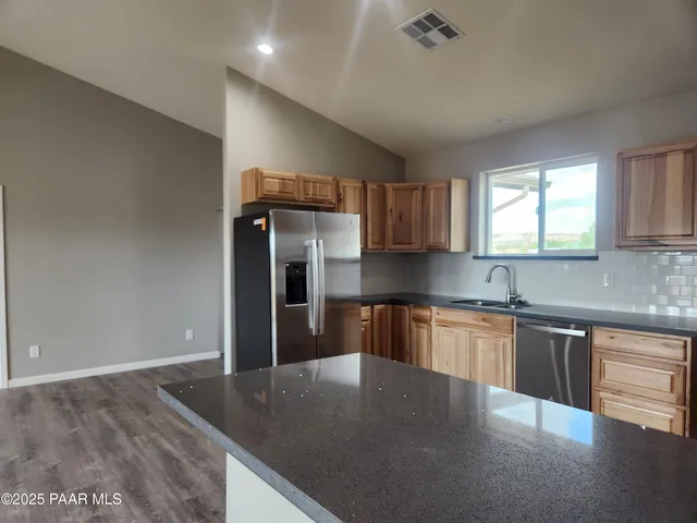 a kitchen with stainless steel appliances granite countertop a sink stove and refrigerator