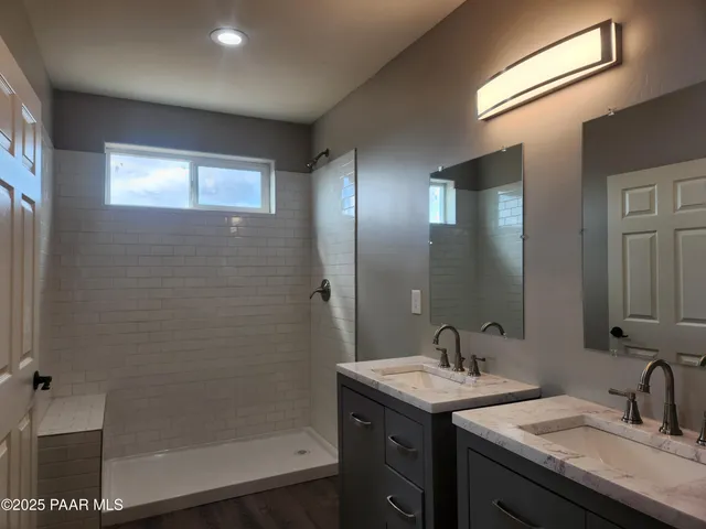 a bathroom with a granite countertop sink a mirror and a shower