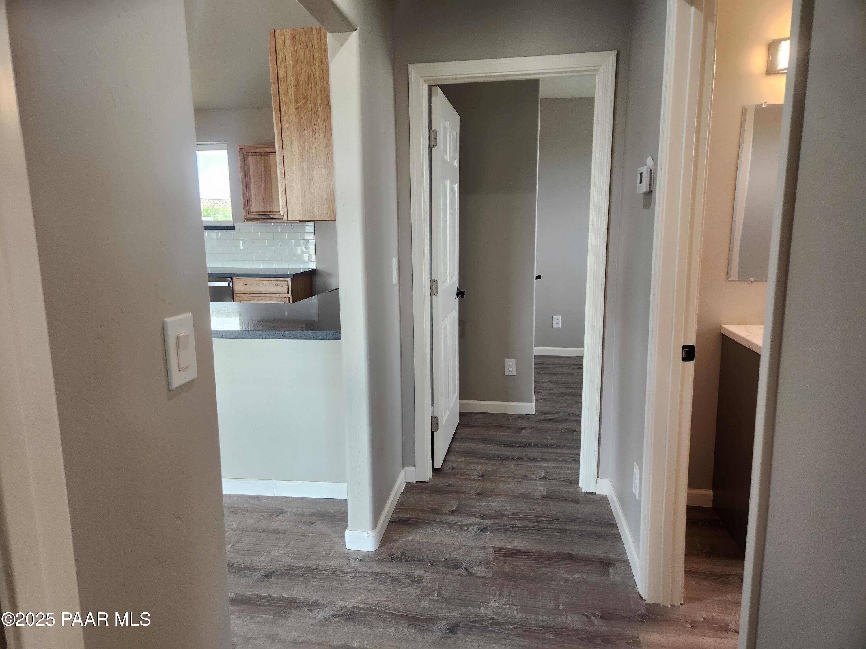895 Ranch House Road Paulden, AZ 86334 - Photo 9 of 21 a view of a hallway with wooden floor cabinets and a kitchen