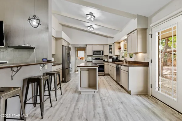 a kitchen with kitchen island granite countertop wooden floors and stainless steel appliances