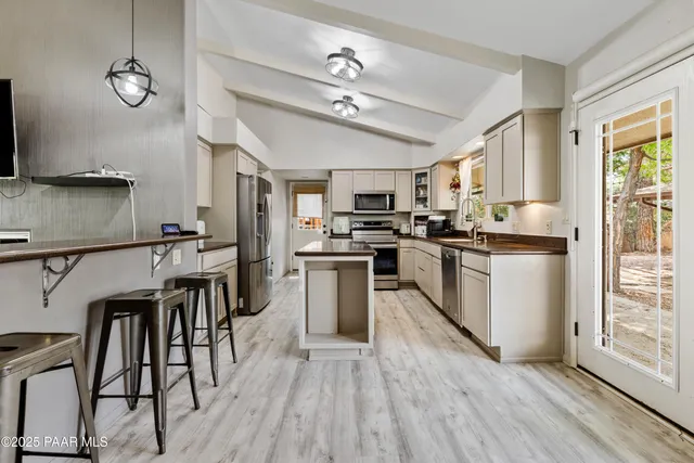 a kitchen with kitchen island granite countertop wooden floors and stainless steel appliances
