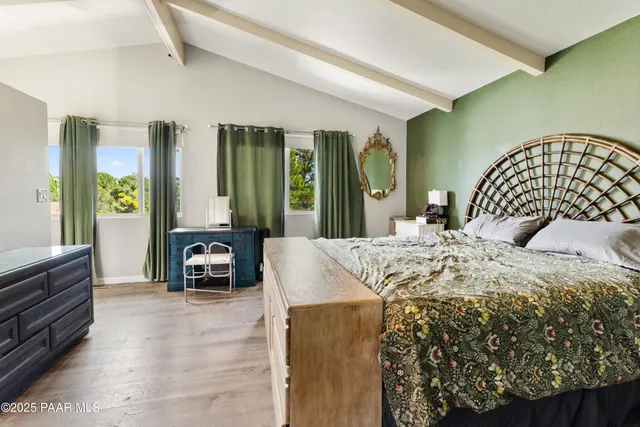 a bedroom with a bed lamp and a large window