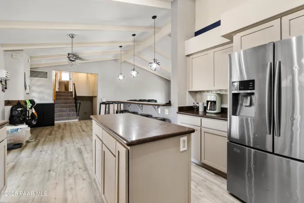 a kitchen with stainless steel appliances granite countertop a refrigerator a sink dishwasher a stove and a refrigerator with wooden floor