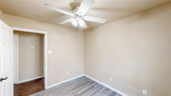 an empty room with windows and fan