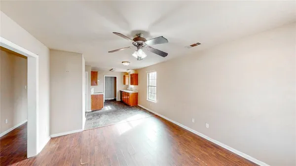 a view of a livingroom with a ceiling fan and wooden floor