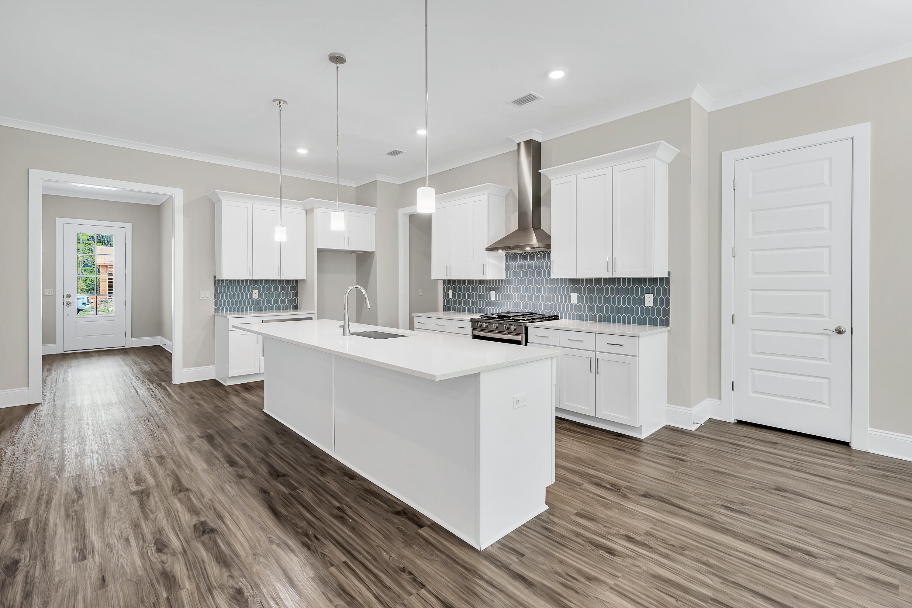 0 South J Hunter's Way, Unit LOT 18 Freeport, FL 32439 - Photo 8 of 36 a kitchen with stainless steel appliances kitchen island wooden floors and white cabinets
