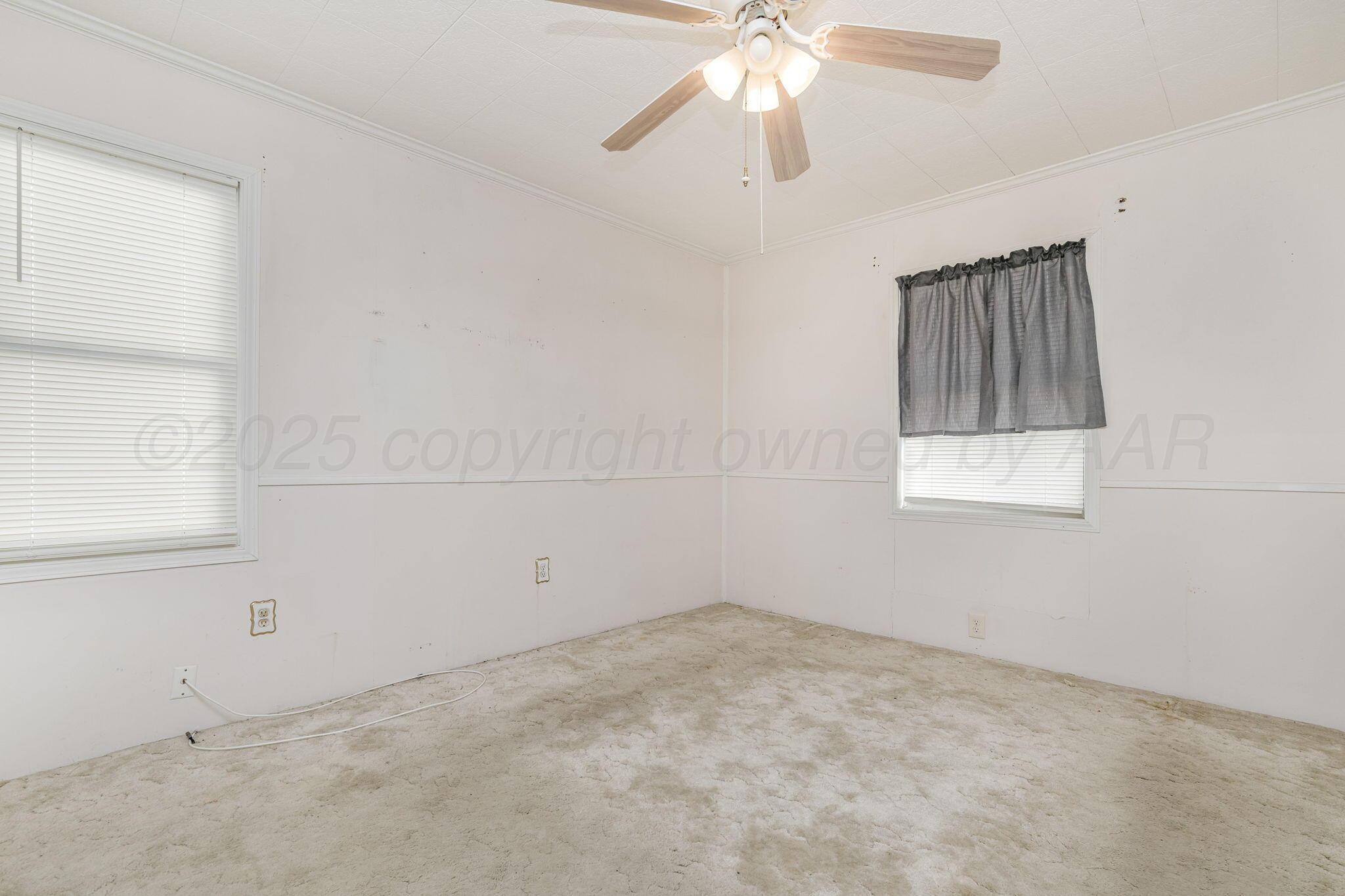 2133 Hamilton Street Pampa, TX 79065 - Photo 14 of 21 an empty room with a window and ceiling fan