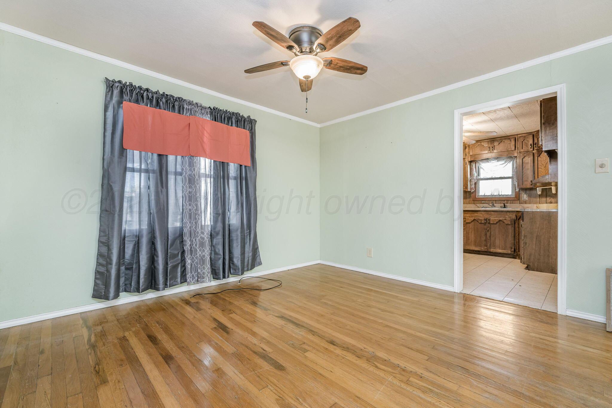2133 Hamilton Street Pampa, TX 79065 - Photo 5 of 21 wooden floor in an empty room with a window