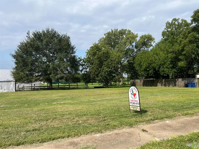 a view of a field with trees in the background
