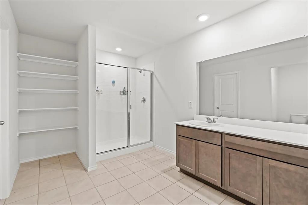 171 Seabiscuit Road Caddo Mills, TX 75135 - Photo 16 of 19 a spacious bathroom with a granite countertop sink and a mirror