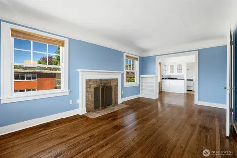 a view of empty room with wooden floor and fireplace