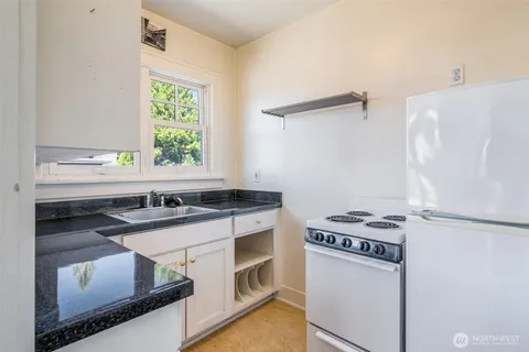 a kitchen with granite countertop a stove and a sink