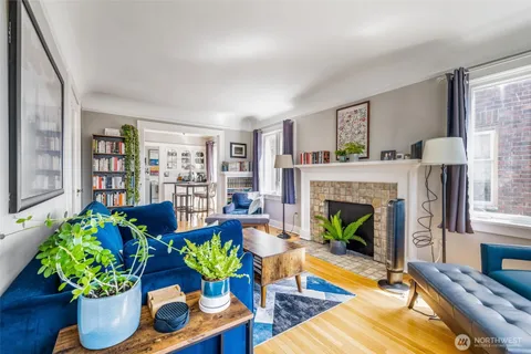 a living room with furniture fireplace and potted plants