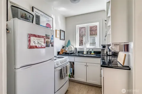 a kitchen with white cabinets and white appliances