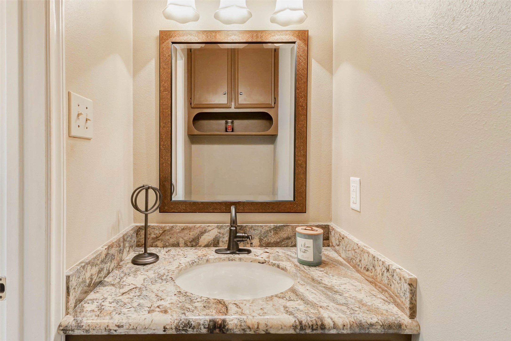 15811 Spring Forest Drive Houston, TX 77059 - Photo 12 of 27 Discover elegance in this charming powder room, featuring a sleek granite countertop, warm lighting, and a stylish mirror that enhances its cozy ambiance.