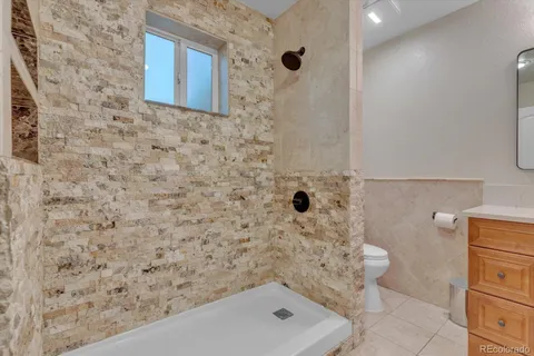 a spacious bedroom with a bed and a chandelier