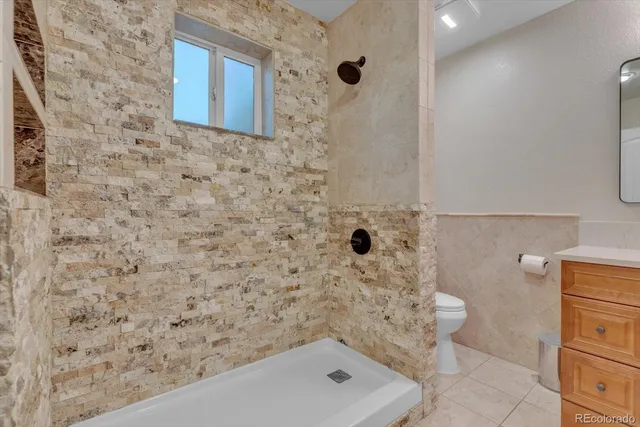 a spacious bedroom with a bed and a chandelier