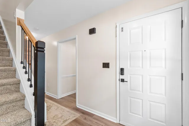 a view of a hallway with wooden floor and entryway