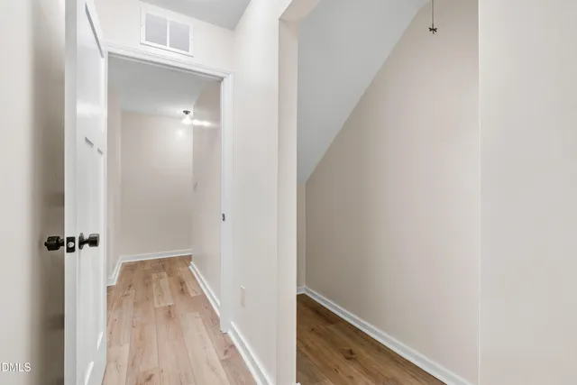 a view of a hallway with wooden floor and staircase