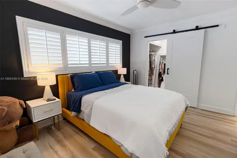 a bedroom with bed and large windows