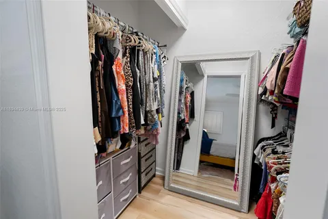 a view of walk in closet with clothes and shoes