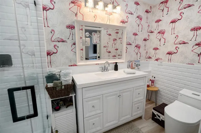 a bathroom with a sink toilet vanity and shower