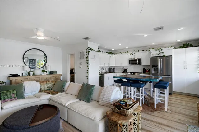 a living room with furniture kitchen view and a wooden floor