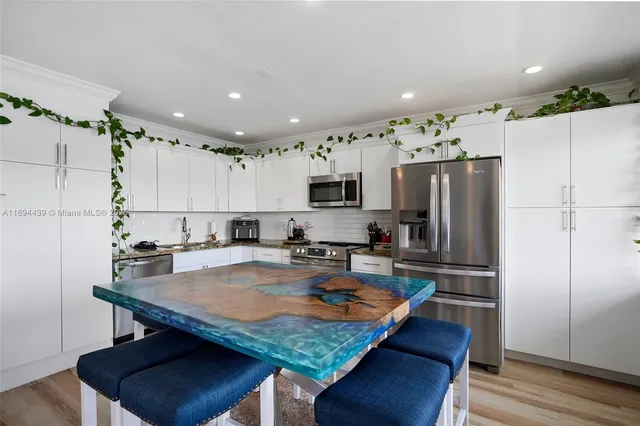 a kitchen with stainless steel appliances granite countertop a stove refrigerator sink and cabinets