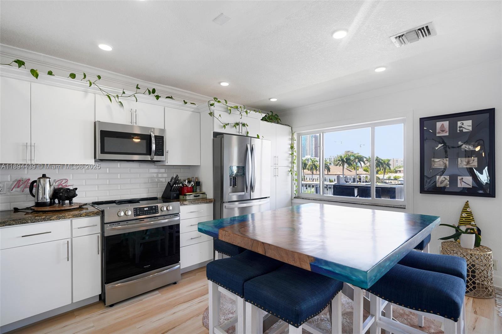 1201 South Riverside Drive, Unit 301 Pompano Beach, FL 33062 - Photo 6 of 24 a kitchen with stainless steel appliances a stove a sink a microwave a refrigerator and cabinets