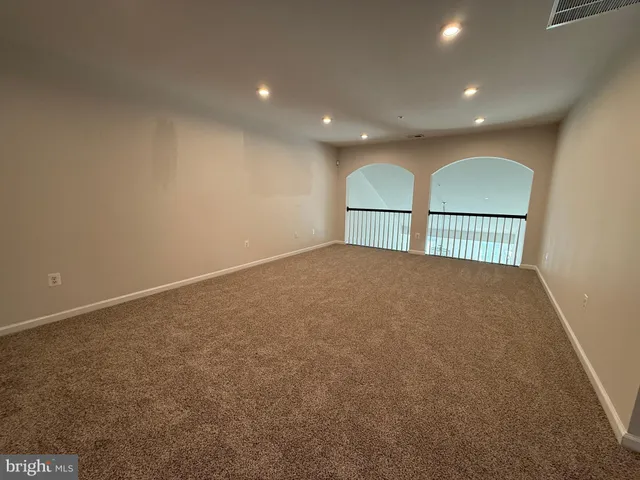 a view of a big room with wooden floor and windows