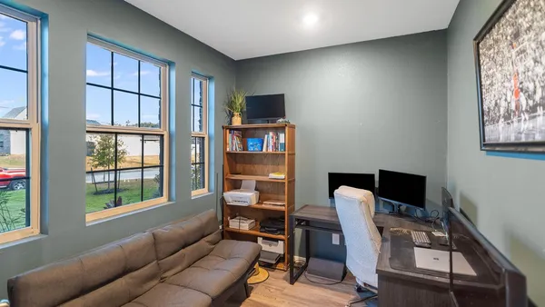 a view of a livingroom with workspace and a window