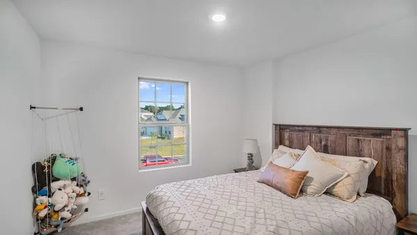 a bedroom with a bed and painting on the wall