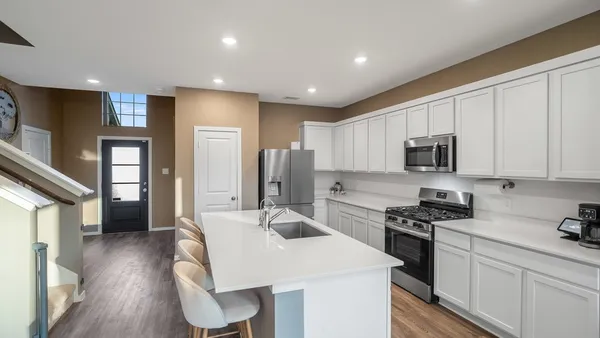 a kitchen with stainless steel appliances kitchen island granite countertop a stove a sink a refrigerator a microwave and cabinets