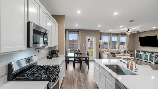 a kitchen with sink stove and cabinets