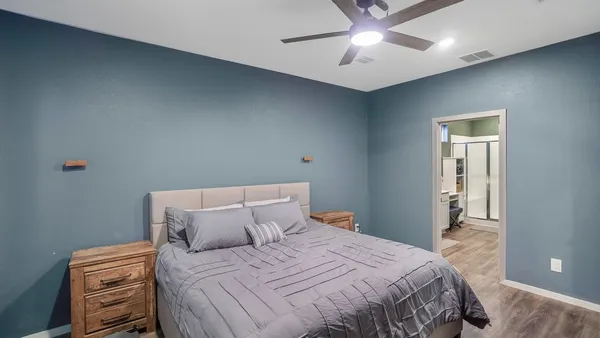 a bedroom with a bed and a ceiling fan