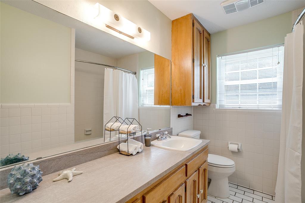 11484 Moran Road Azle, TX 76020 - Photo 25 of 40 Full bathroom featuring tile walls, vanity, light tile patterned flooring, and curtained shower