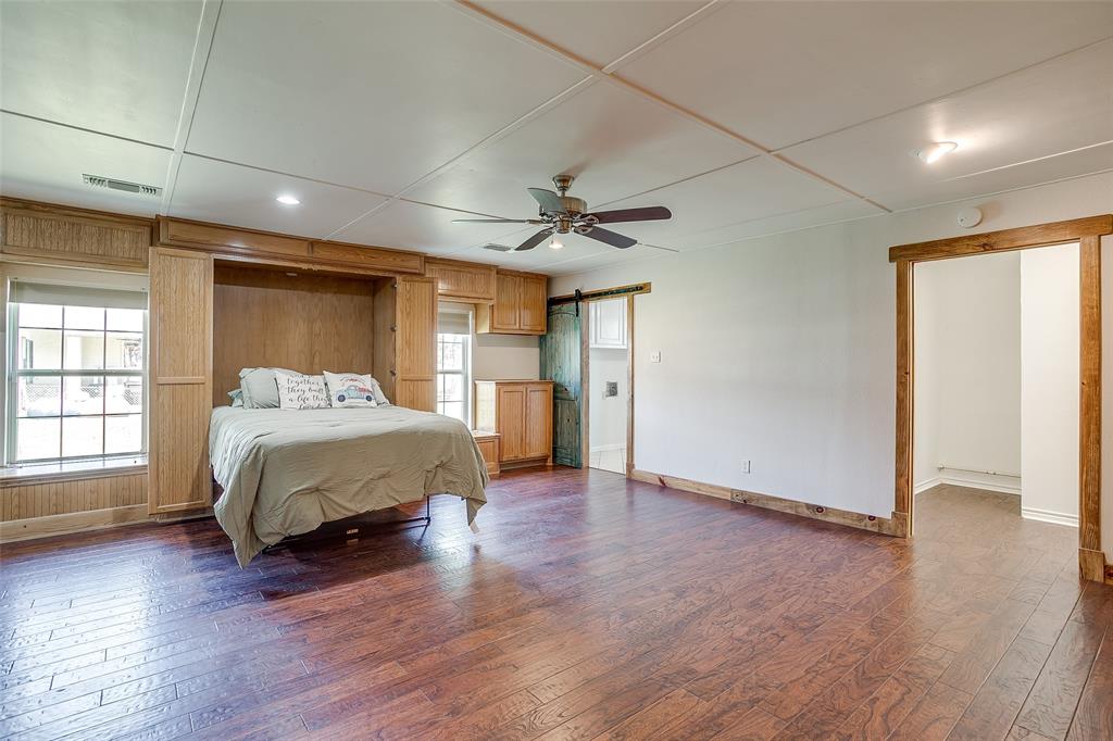 11484 Moran Road Azle, TX 76020 - Photo 27 of 40 Bedroom with a barn door, dark wood-style flooring, a ceiling fan, murphy bed
