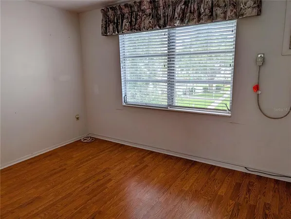 a view of a small space with wooden floor and a window